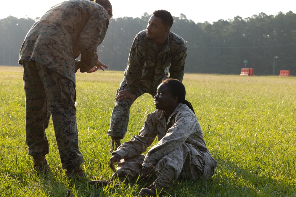 Marines with Marine Corps Combat Service Support Schools maneuver through an obstacle course