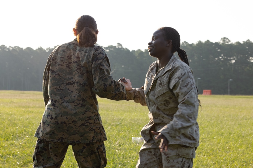 Marines with Marine Corps Combat Service Support Schools maneuver through an obstacle course