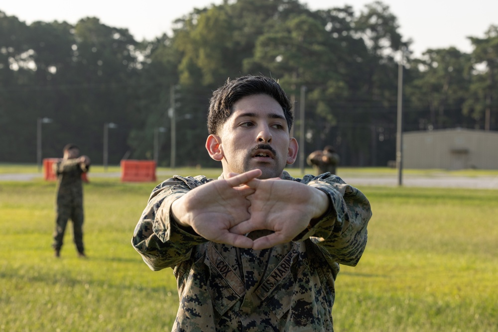 Marines with Marine Corps Combat Service Support Schools maneuver through an obstacle course