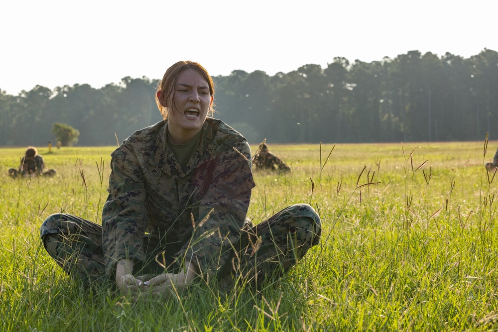 Marines with Marine Corps Combat Service Support Schools maneuver through an obstacle course