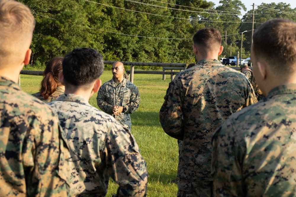 Marines with Marine Corps Combat Service Support Schools maneuver through an obstacle course