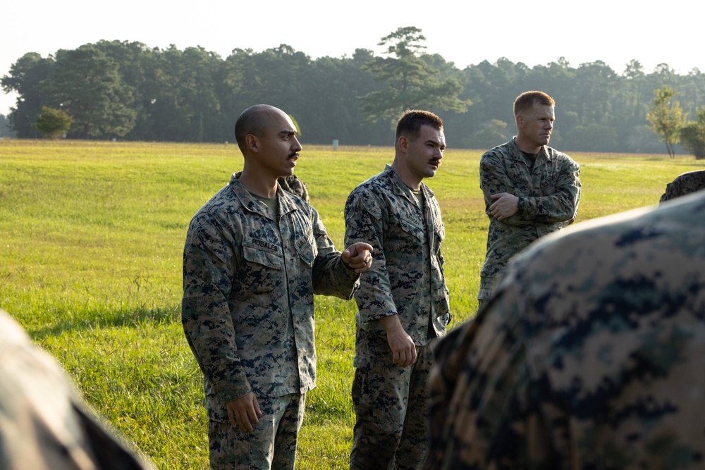 Marines with Marine Corps Combat Service Support Schools maneuver through an obstacle course