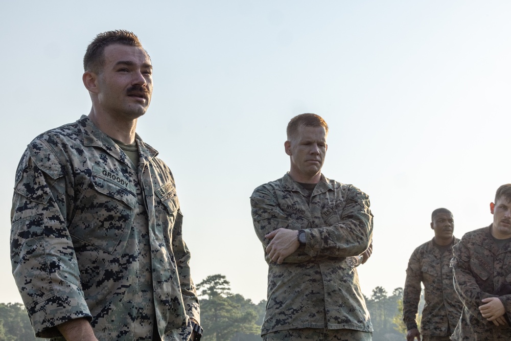 Marines with Marine Corps Combat Service Support Schools maneuver through an obstacle course