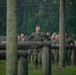 Marines with Marine Corps Combat Service Support Schools maneuver through an obstacle course