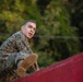 Marines with Marine Corps Combat Service Support Schools maneuver through an obstacle course