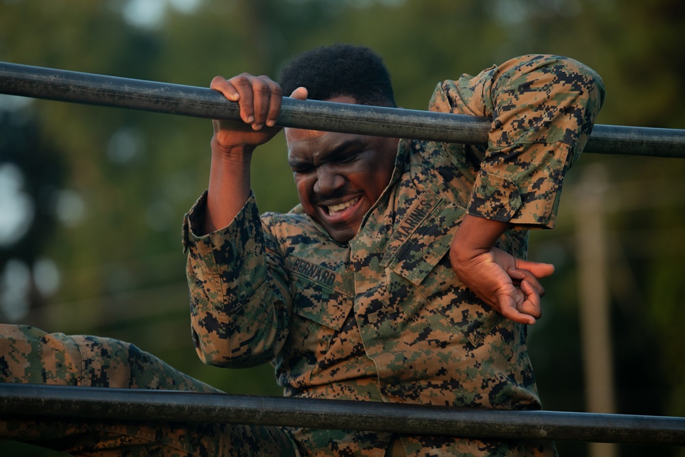 Marines with Marine Corps Combat Service Support Schools maneuver through an obstacle course