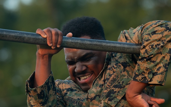 Marines with Marine Corps Combat Service Support Schools maneuver through an obstacle course