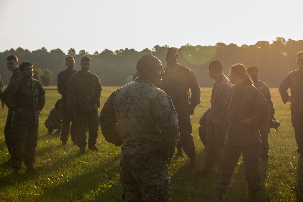 Marines with Marine Corps Combat Service Support Schools maneuver through an obstacle course