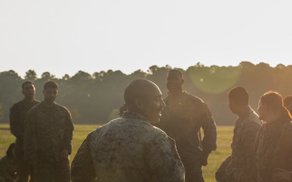 Marines with Marine Corps Combat Service Support Schools maneuver through an obstacle course