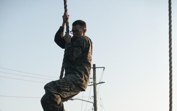 Marines with Marine Corps Combat Service Support Schools maneuver through an obstacle course