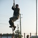 Marines with Marine Corps Combat Service Support Schools maneuver through an obstacle course