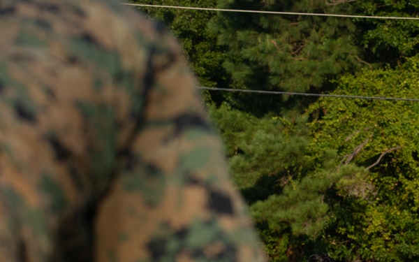 Marines with Marine Corps Combat Service Support Schools maneuver through an obstacle course