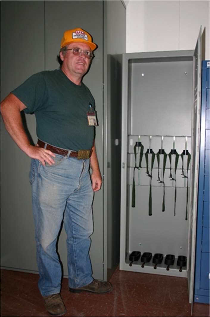 Army Sustainment Command G4 (Logistics) engineer William Ellis examines a weapons storage locker.