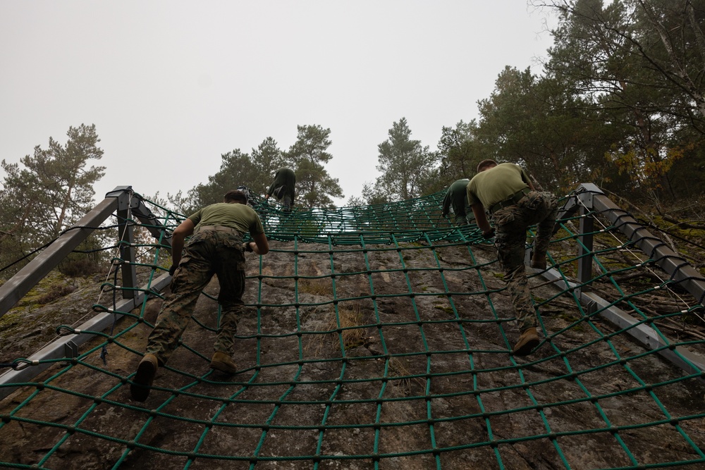 Swedish service members lead U.S. Marines through obstacle course