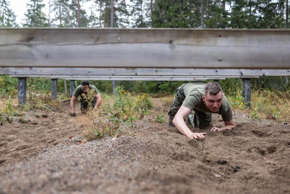 Swedish service members lead U.S. Marines through obstacle course