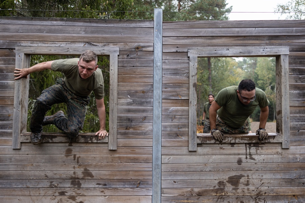 Swedish service members lead U.S. Marines through obstacle course