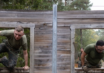 Swedish service members lead U.S. Marines through obstacle course