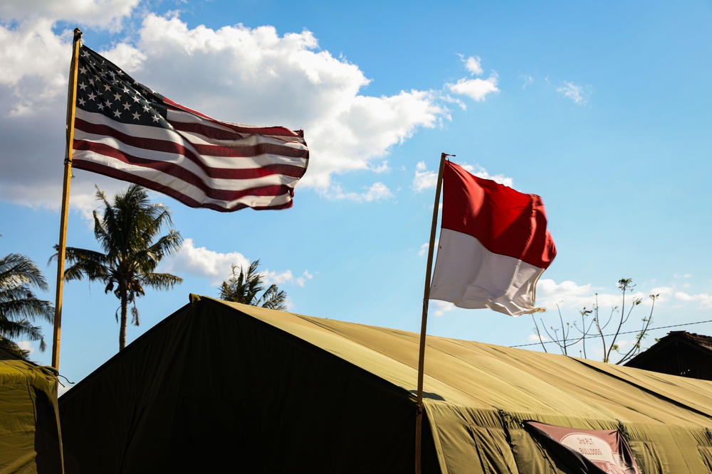 The flags of the United States of America and the Republic of Indonesia fly above Sekolah Dasar Negeri 2, during Super Garuda Shield 2024