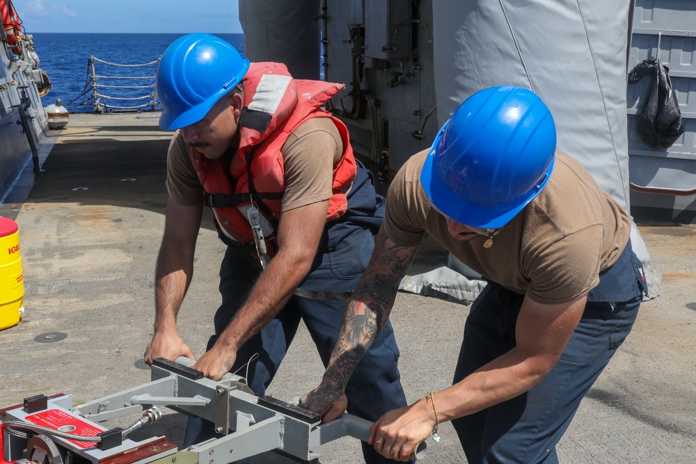 Sailors aboard the USS Howard conduct a torpedo download in the East China Sea