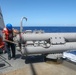 Sailors aboard the USS Howard conduct a torpedo download in the East China Sea