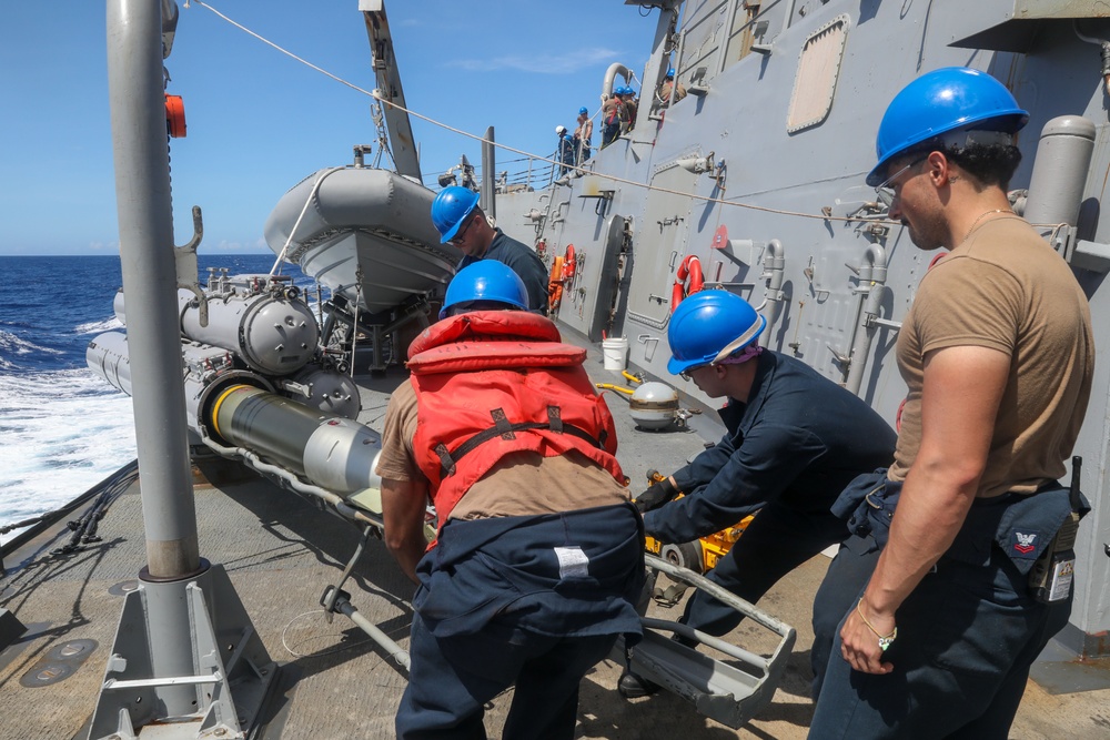Sailors aboard the USS Howard conduct a torpedo download in the East China Sea