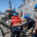 Sailors aboard the USS Howard conduct a torpedo download in the East China Sea