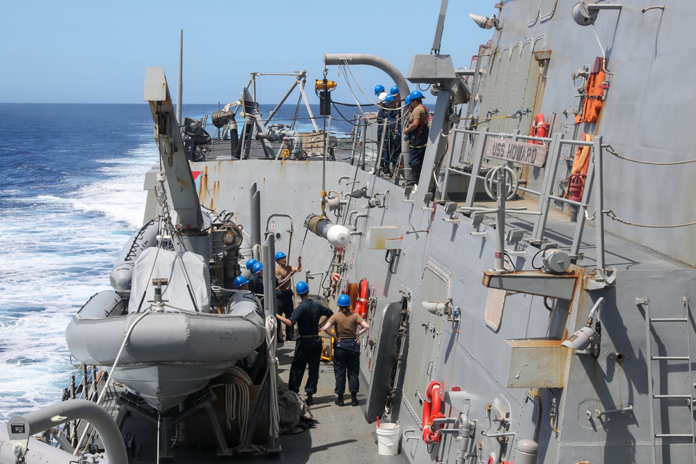 Sailors aboard the USS Howard conduct a torpedo download in the East China Sea