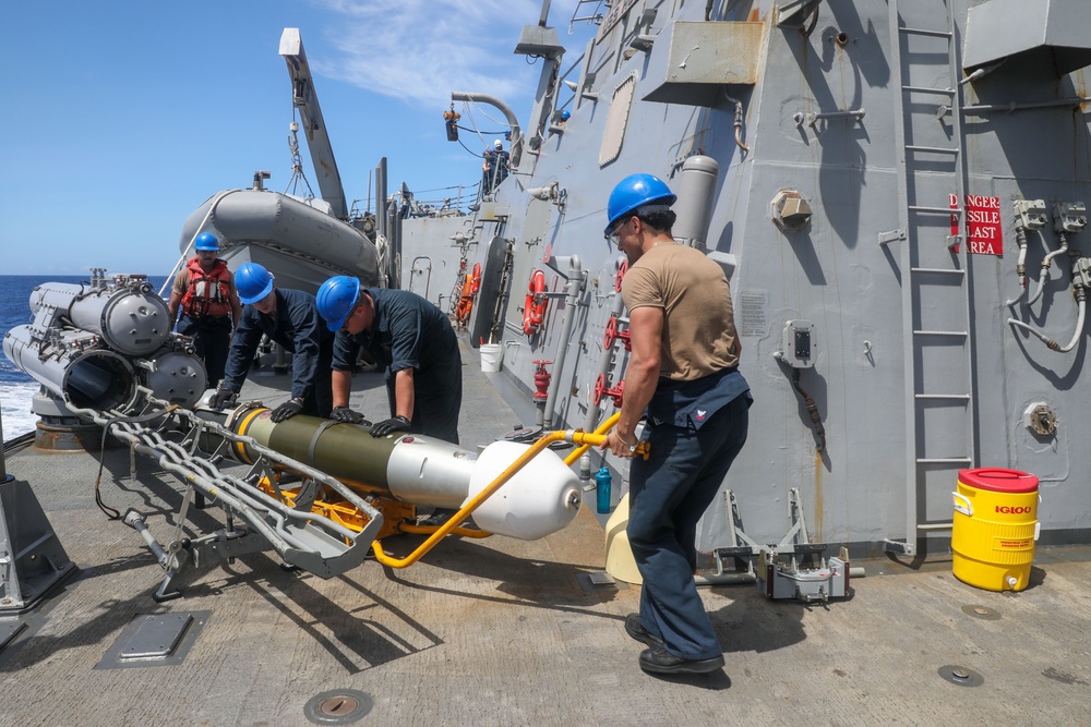 Sailors aboard the USS Howard conduct a torpedo download in East China Sea