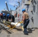 Sailors aboard the USS Howard conduct a torpedo download in East China Sea