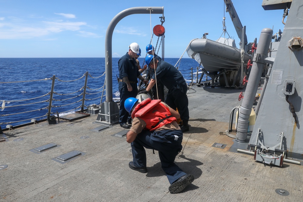 Sailors aboard the USS Howard conduct a torpedo download in East China Sea