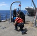 Sailors aboard the USS Howard conduct a torpedo download in East China Sea