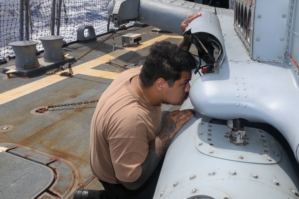 Sailors aboard the USS Howard conduct routine maintenance on a Sea Hawk helicopter (MH-60R) in the Philippine Sea