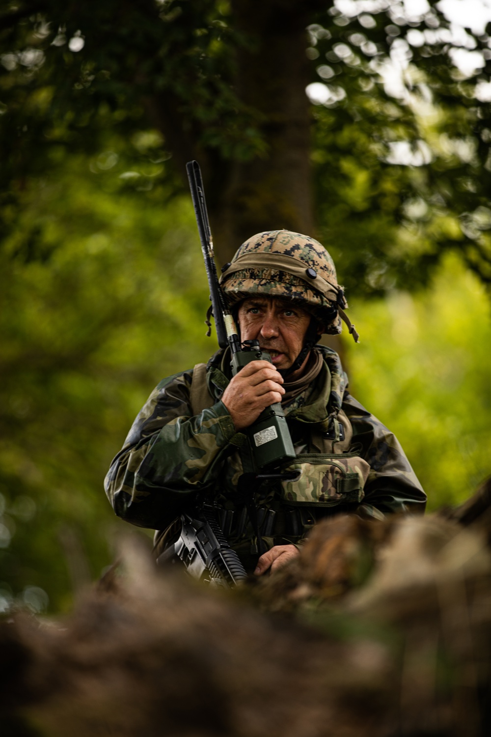 Bosnian soldier communicates with team while holding security