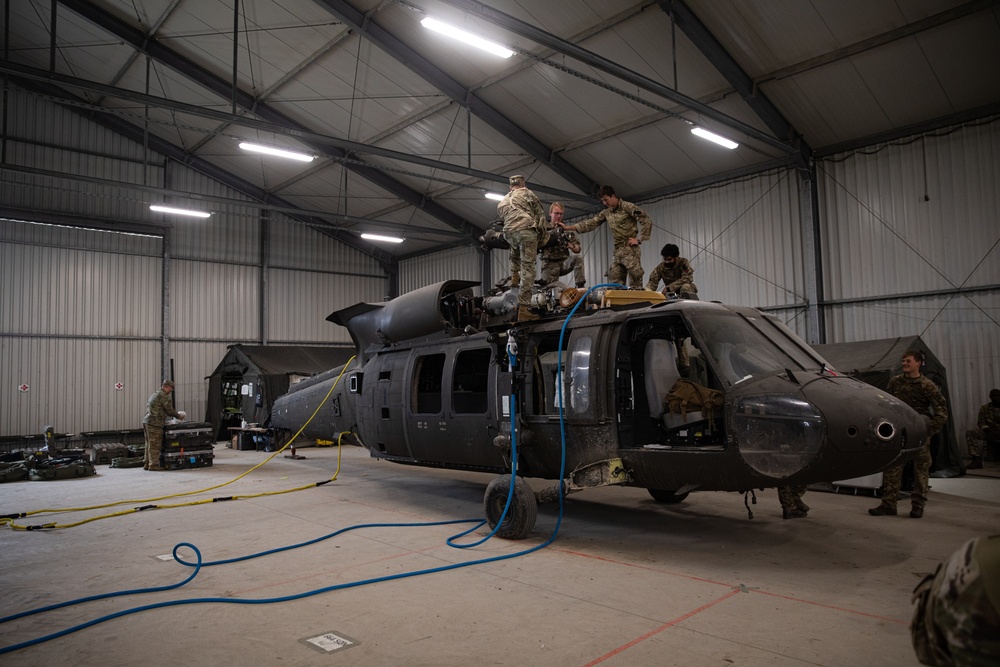 U.S. Soldiers salvage parts from Black Hawk helicopter