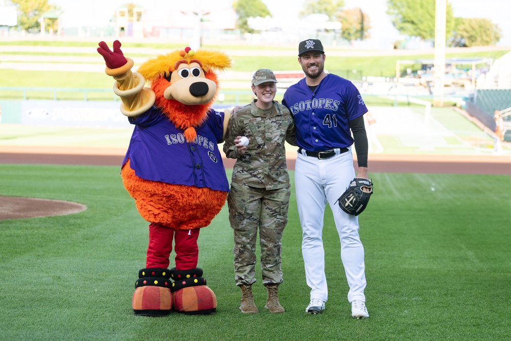 SrA Rachel Heath poses with Isotopes player Geoff Hartlieb and Orbit the mascot