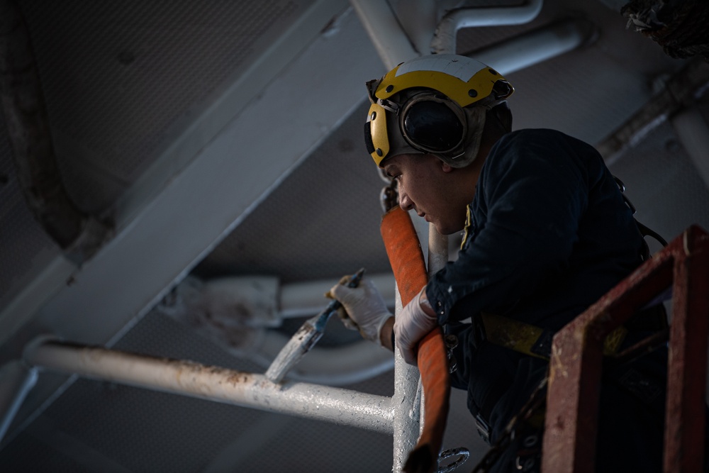 A Nimitz Sailor Paints in the Hangar Bay