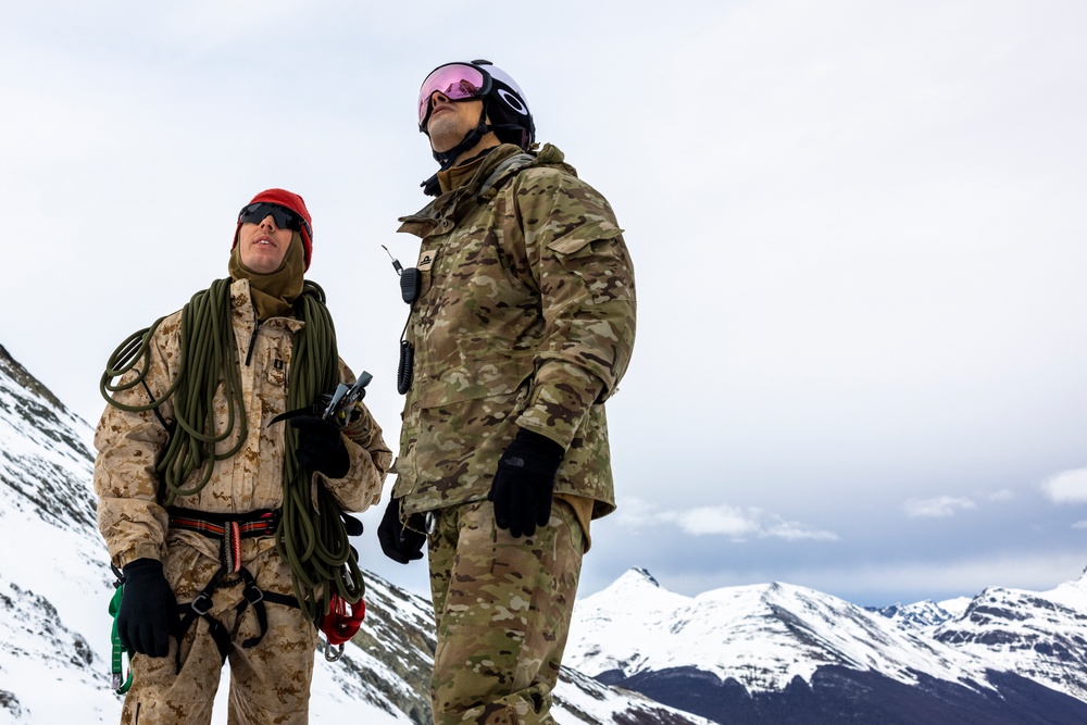 U.S. Marine Corps Mountain Warfare Instructors climb an ice wall with Argentine marines