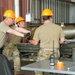 1st Lt Stephanie Walker of the 104th FW and TSgt Daniel Glass of the 162nd WG work together to manually move a 2000lb, BLU-109 bomb body into position for assembly during their day of competition.