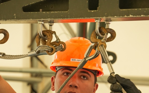 Staff Sgt. Matthew Garcia, assigned to the 5th Bomb Wing at Minot Air Force Base, N.D., attaches slings to a 2,000-lb, Mark-84 general purpose heavy unguided bomb body during the 2024 Ammo Rodeo at Volk Field, Wis.