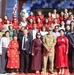 Attendees pose for a photo on the front steps of the new school after the ceremony