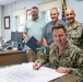 NSA Souda Bay Commanding Officer Capt. Stephen Steacy signs proclamation recognizing nation preparedness month.