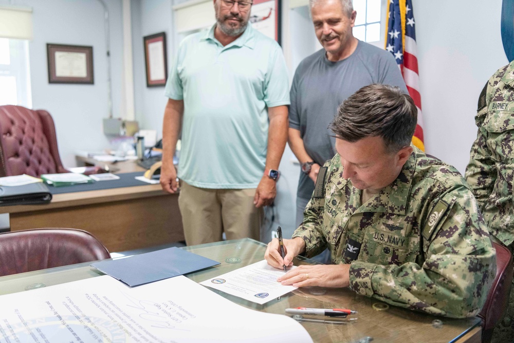 NSA Souda Bay Commanding Officer Capt. Stephen Steacy signs proclamation recognizing nation preparedness month.