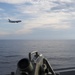 A P-8 Poseidon Maritime Patrol aircraft conducts a fly by USS Howard in the South China Sea