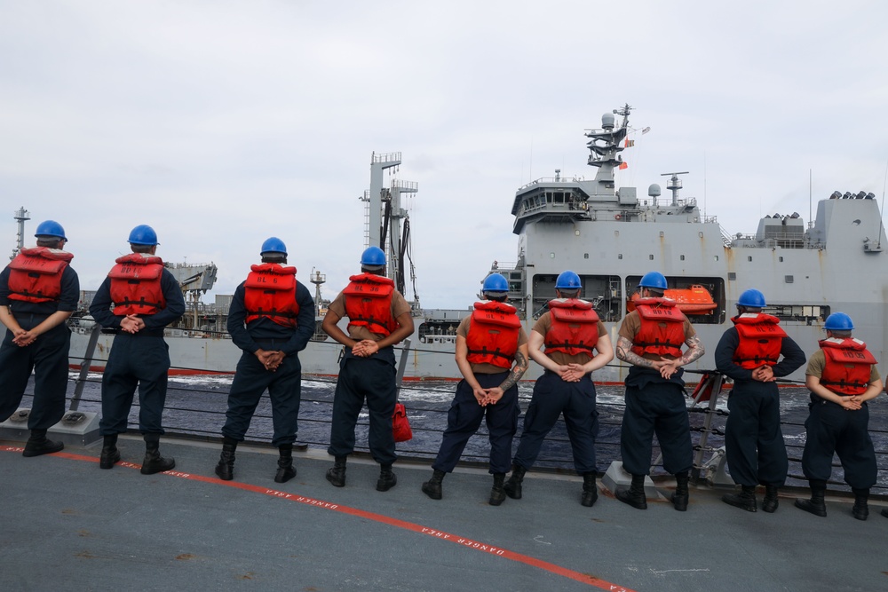 Sailors aboard the USS Howard conduct a replenishment-at-sea the HMNZS Aotearoa in the South China Sea