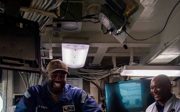 Sailor speaks to members of the Royal Australian Air Force in flight deck control aboard Nimitz-class aircraft carrier USS Carl Vinson (CVN 70).