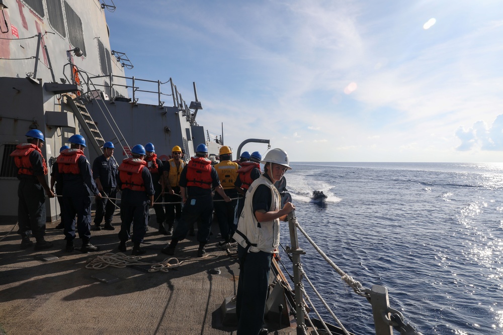 Sailors aboard the USS Howard conduct a passenger transfer with sailors aboard the HMAS Sydney V in the South China Sea