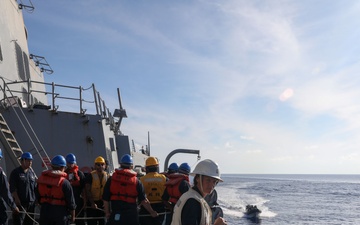 Sailors aboard the USS Howard conduct a passenger transfer with sailors aboard the HMAS Sydney V in the South China Sea