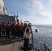 Sailors aboard the USS Howard conduct a passenger transfer with sailors aboard the HMAS Sydney V in the South China Sea