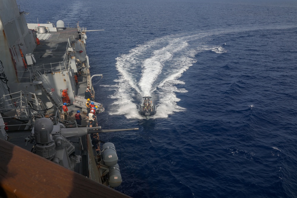 Sailors aboard the USS Howard conduct a passenger transfer with sailors aboard the HMAS Sydney V in the South China Sea