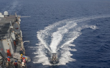 Sailors aboard the USS Howard conduct a passenger transfer with sailors aboard the HMAS Sydney V in the South China Sea